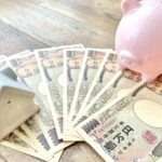 家の模型と一万円札と豚の貯金箱