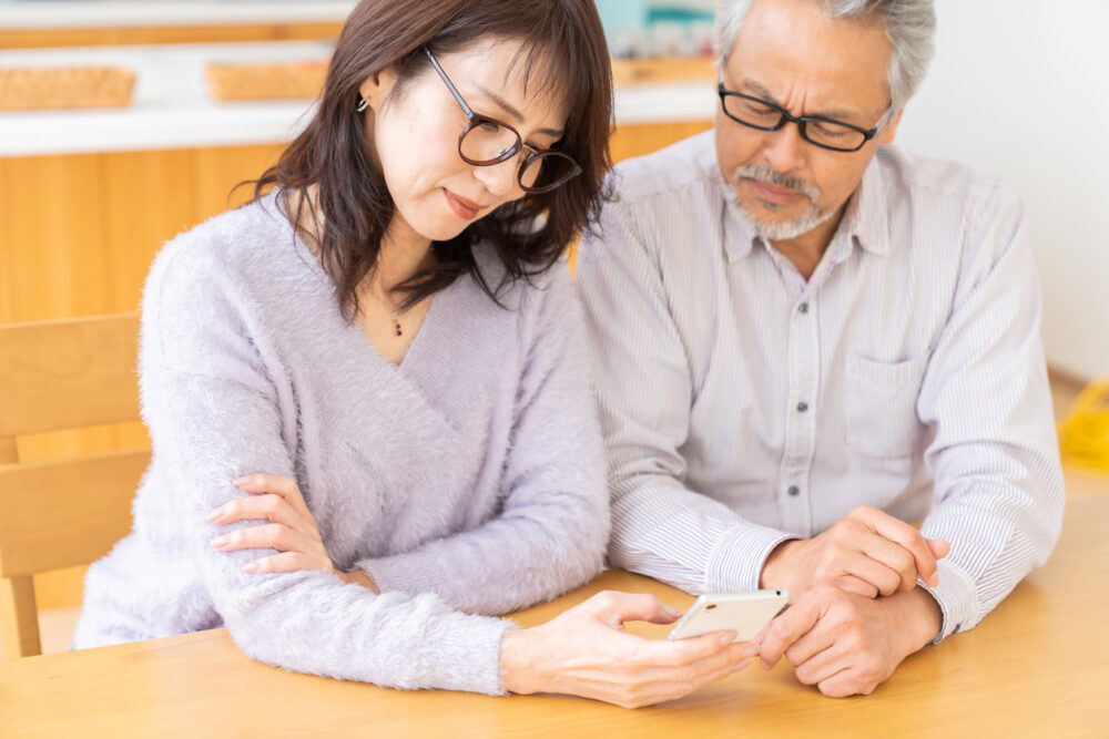 asian senior age couple using a smart phone, trouble