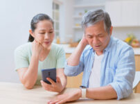 asian elderly couple use smartphone connected with smart watch to track health - they feel worried